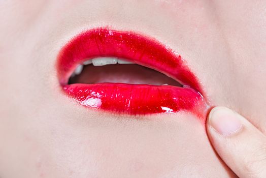 Woman lips with lipsticks smeared on skin