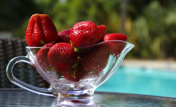 Strawberry on the table by the swimming pool