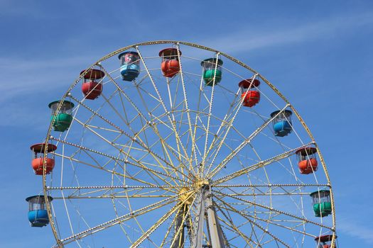 Atraktsion colorful ferris wheel against the blue sky