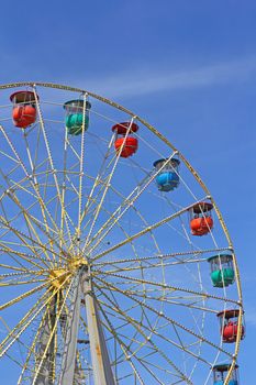 Atraktsion colorful ferris wheel against the blue sky