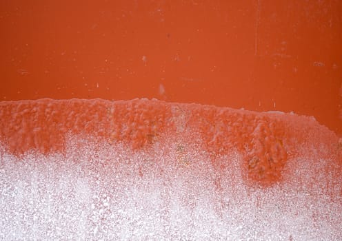 background of rusty iron tin wall partly frozen with ice in winter.