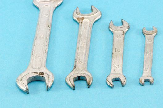 set different size hand wrench screw tools on blue background.