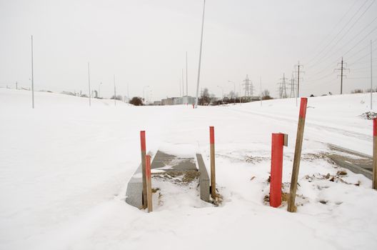 road sidewalk construction work site covered with snow in winter.