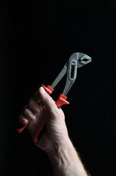 Pliers and Hand on a Black Background