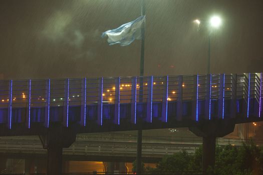 night view of buenos aires in the rain and the Argentine flag