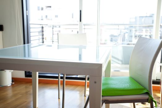 table and chairs in front of windows in the room