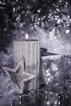 Christmas candle with gift and different silver decoration