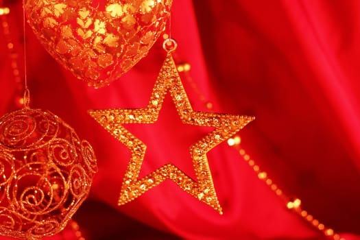 Golden christmas decoration on red fabric background