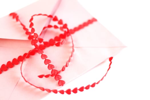 Envelope with red hearts ribbon isolated on white background