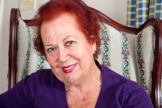 Red haired senior grandmother smiling at you with genuine trustfull look