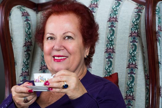 Senior woman having strong Turkish coffee and have a pleasant smile on her face