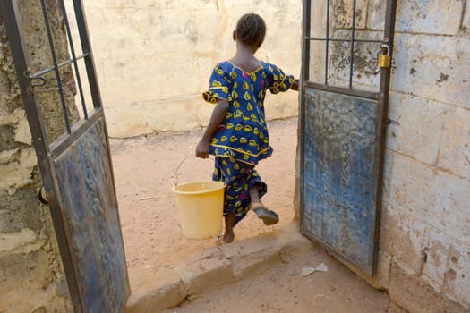 African child with a bucket full of water
