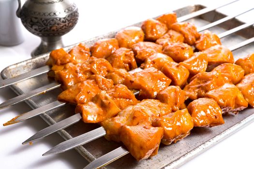 Well seasoned chicken skewers are waiting on aluminum tray, ready to go on to the grill and cook