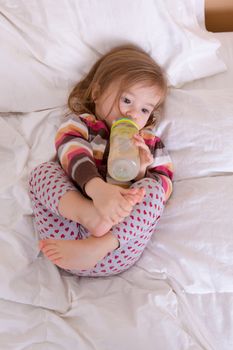 Toddler girl getting ready to sleep, having her drink before fall asleep
