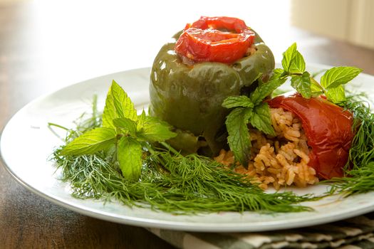 Seasoned riice stuffed bellpepper and domatoes served with greens