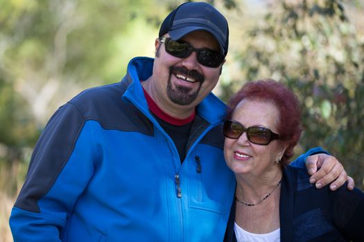 Proud mother with her grown up son, outside, both in sunglasses