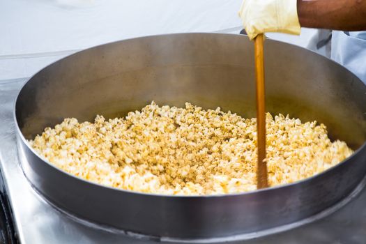 Twirling popcorn's in the huge pan going crazy and popping