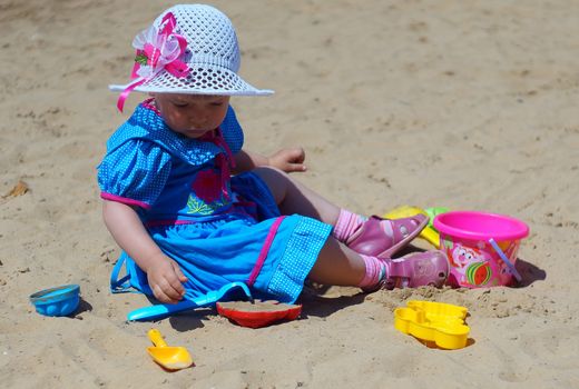 Two-year-old girl playing in a sandbox