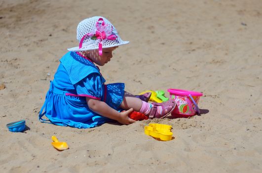 Two-year-old girl playing in a sandbox