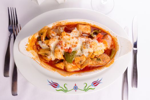 Chicken Saute baked with bell peppers, tomatoes, mushrooms and  chicken meatballs served in a oval shaped dish, top view