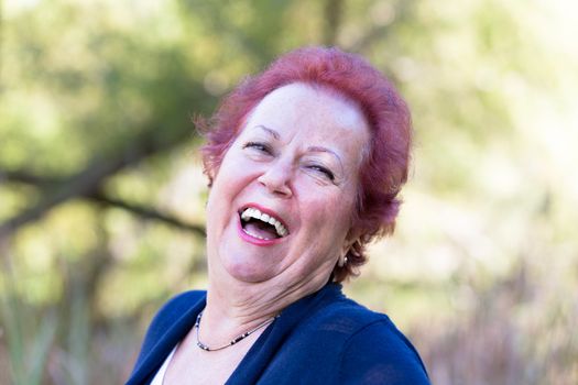 Red hair enthusiastic senior woman giving a genuine laugh