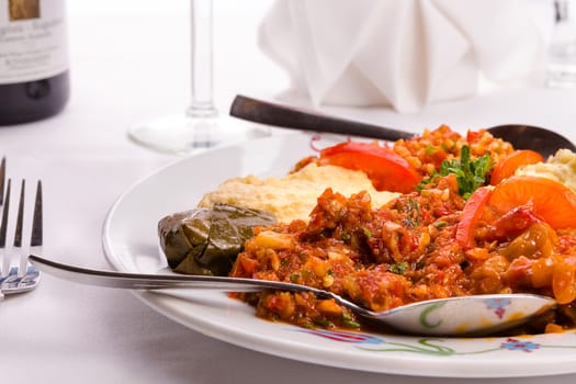 Appetizer sampler plate with Turkish ezme, hummus, babaganoush and dolma served with couple spoons