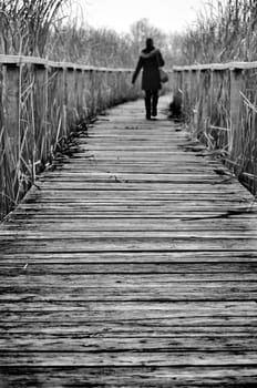 Girl walking on a path covered by wood