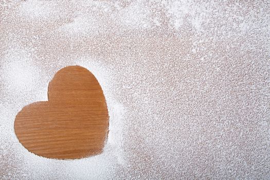 Heart in snow on a wooden background, a Valentine's Day theme