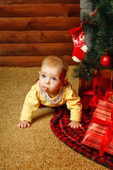 Redhead babe with blue eyes lies near the Christmas tree and gifts