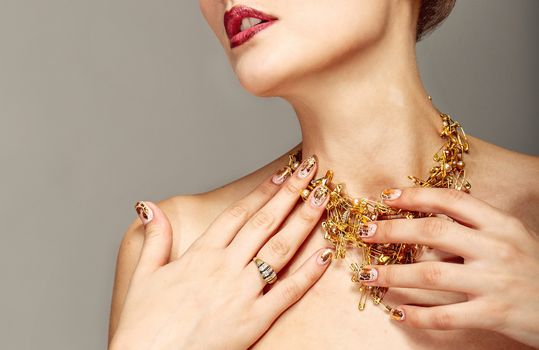 Trendy nail design and beautiful necklace of golden pins safe