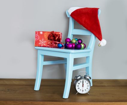 santa claus hat on chair with presents and balls for christmas