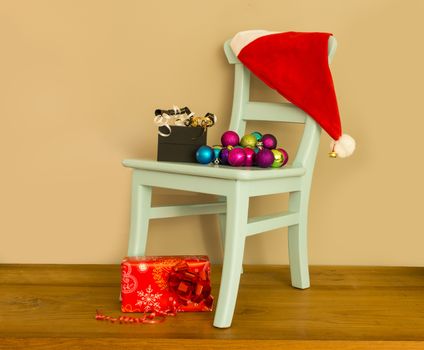santa claus hat on chair with presents and balls for christmas