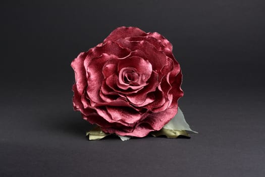 Artificial red rose at dark background