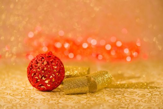 Red Christmas decorations on golden background with red lights blur