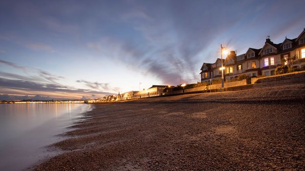 Nightime seascape in dorset with houses over looking the seafront at sunset almost dusk