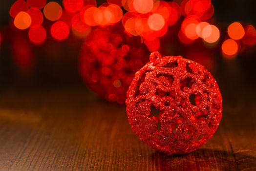 Red Christmas ornament with red blur lights on wooden base