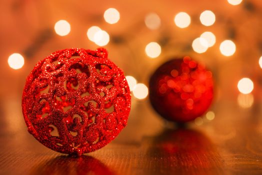 Two red Christmas ornaments on wooden base