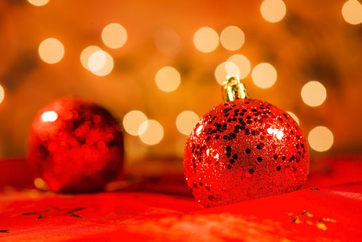 Two red Christmas ornaments with light blur background