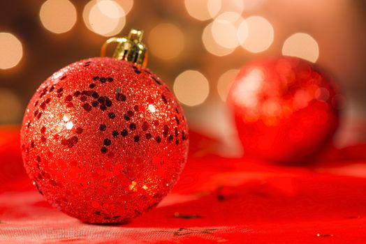 Two red Christmas ornaments with light blur background