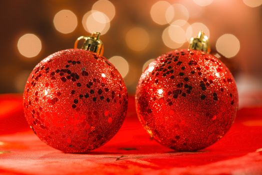Two red Christmas ornaments with light blur background