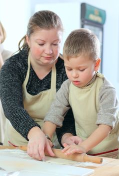 Little boy with his mother cooking at the kitchen