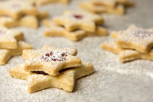 christmas cookies as stars with jam on baking paper