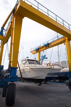 Boat wheel crane elevating motorboat to yearly paint task