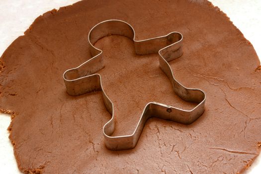 Gingerbread man cookie cutter on rolled out dough