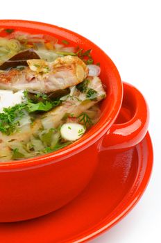 Vegetable Soup with Smoked Pork Ribs, Cabbage, Leek, Carrot, Garlic and Greens in Red Bowl isolated on white background