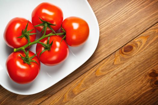 Red tomatoes on wooden table, top view with copy space