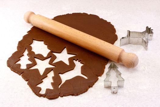 Rolling pin and festive cookie cutters with gingerbread dough - reindeer, Christmas tree, star and holly leaf