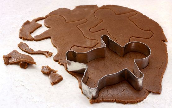 Gingerbread man shapes and cutter in cookie dough