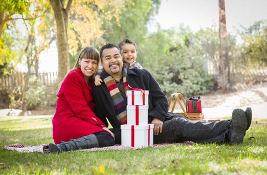 Young Mixed Race Family Enjoying Christmas Gifts in the Park Together.