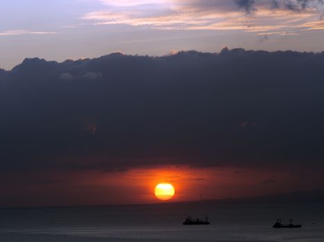 ships in the ocean at sunset